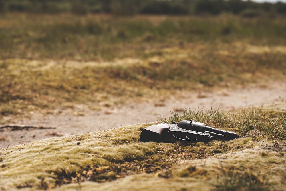 Pistolet revolver noir au sol pendant la journée