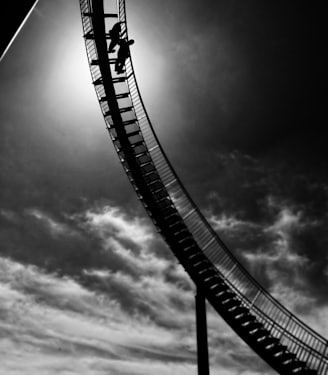 garyscale of two person standing on metal stai