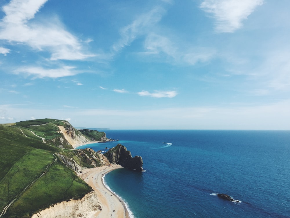 Île verte et brune à côté d’un plan d’eau