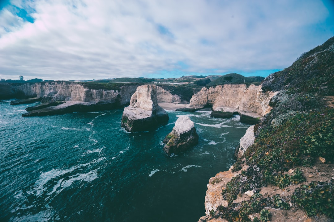 landscape photo of green and brown cliffs, Beautiful cliff around beach