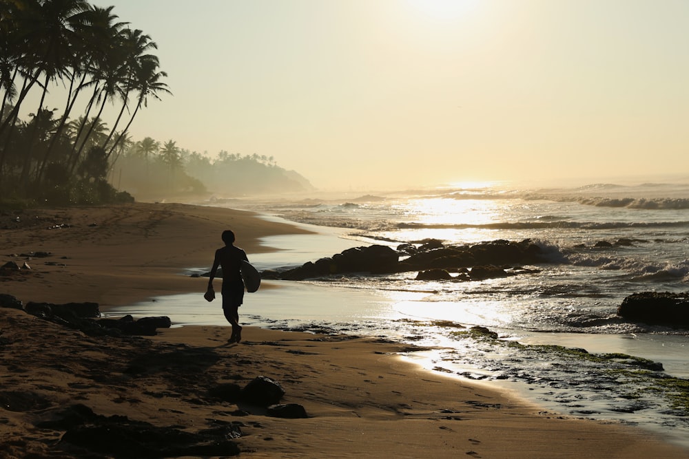 silhouette of person walking on seashore