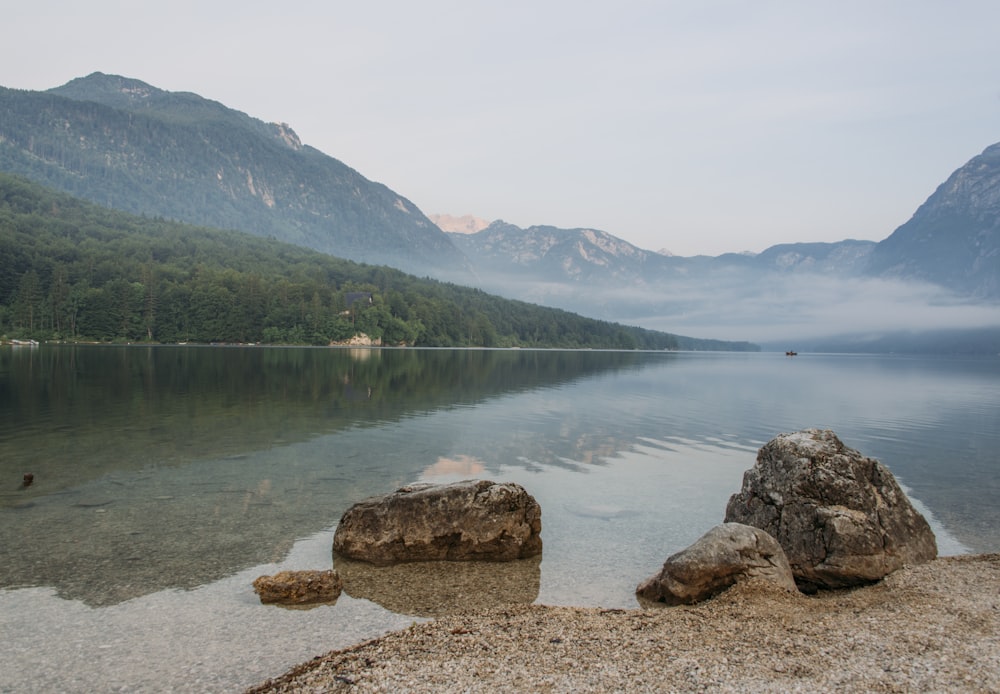 calm body of water near mountains