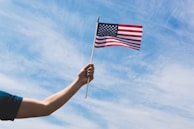 A close-up of hands holding a small American flag.
