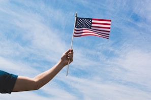 A close-up of hands holding a flag, representing honor and dedication.