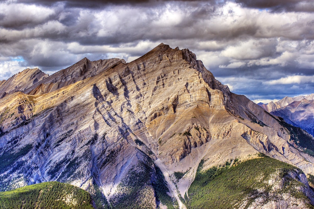 brown mountain range under cloudy sky