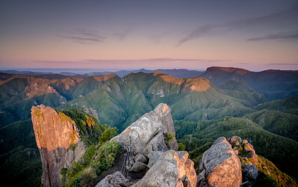 gray stone formation overlooking green hills during golden hour