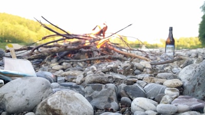 Close-up of hands purifying water using natural materials beside a campfire.
