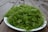 A serene close-up of fresh green herbs gently resting on a wooden table.
