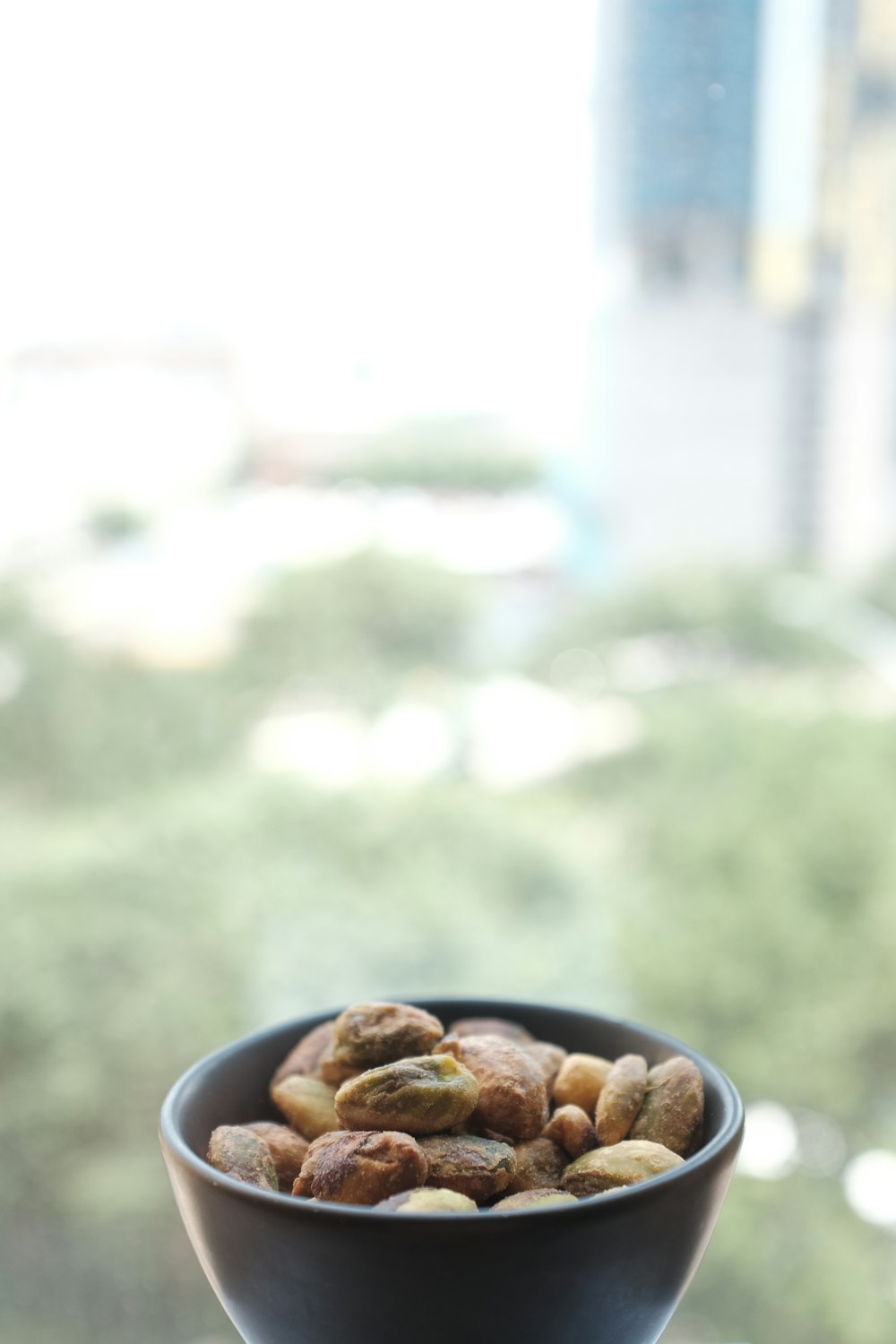 selective focus photography of nuts on black ceramic bowl
