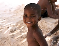Children playing on the sandy shore near Ponto Beach with smiles and laughter.