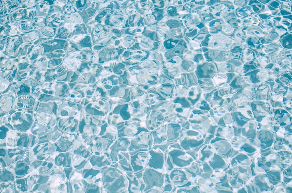 澄んだ青い水と泡のあるプール