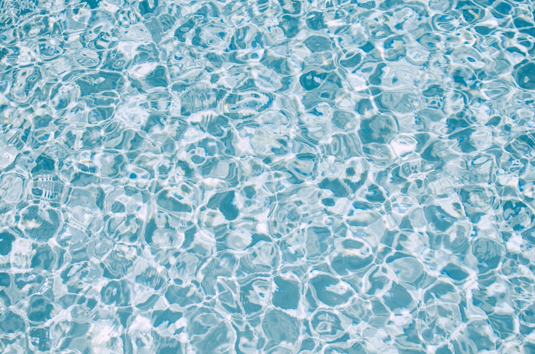 a pool with clear blue water and bubbles,