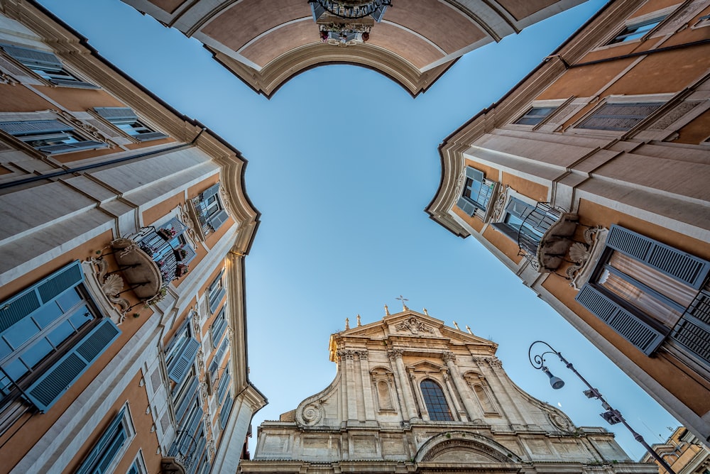 Fotografía de ángulo bajo de edificios blancos y naranjas bajo el cielo azul