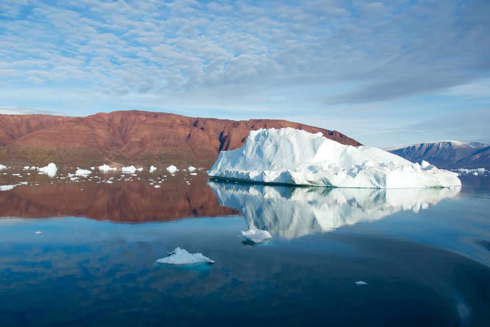 white ice formation on body of water under cloudy sky