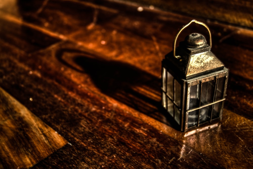 rectangular grey metal candle lantern on brown wooden surface