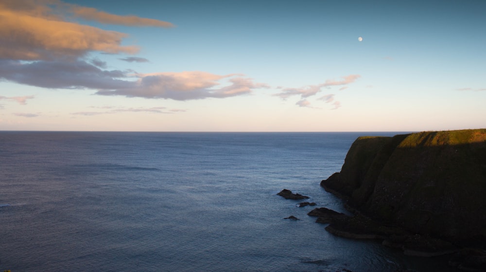 calm ocean waves and brown stone mountain cliff