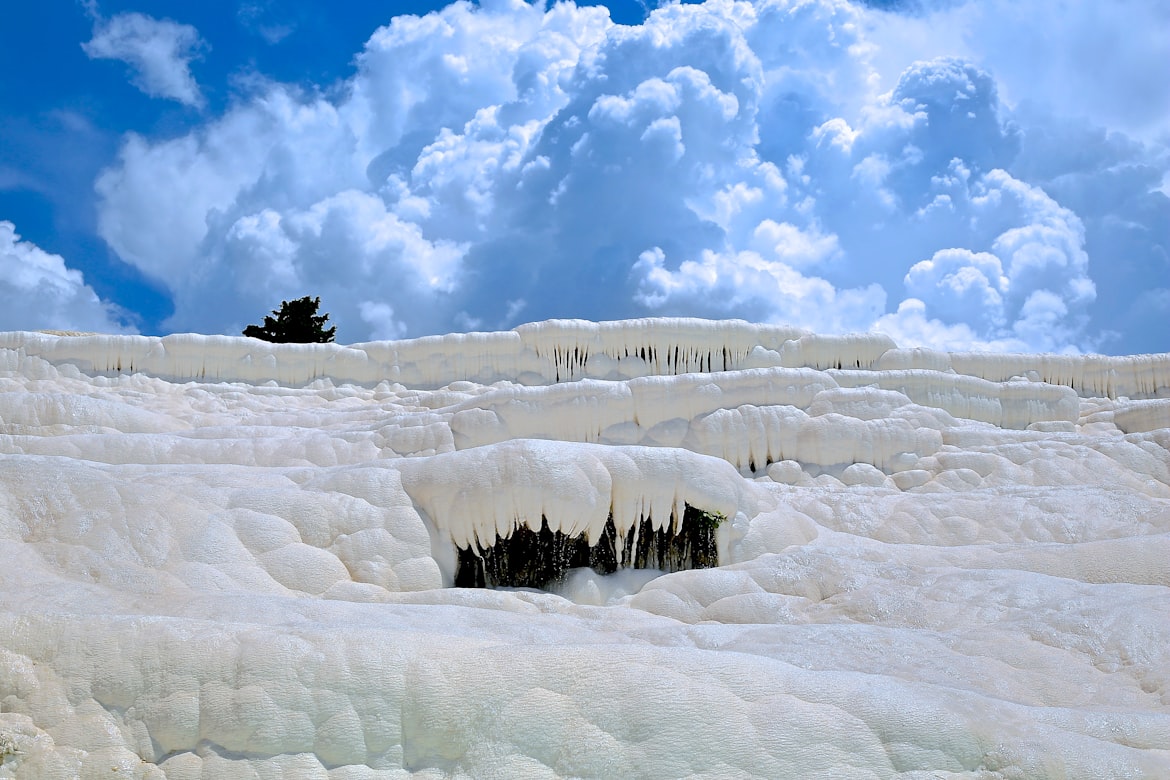 Frozen snow touching a blue cloudy sky