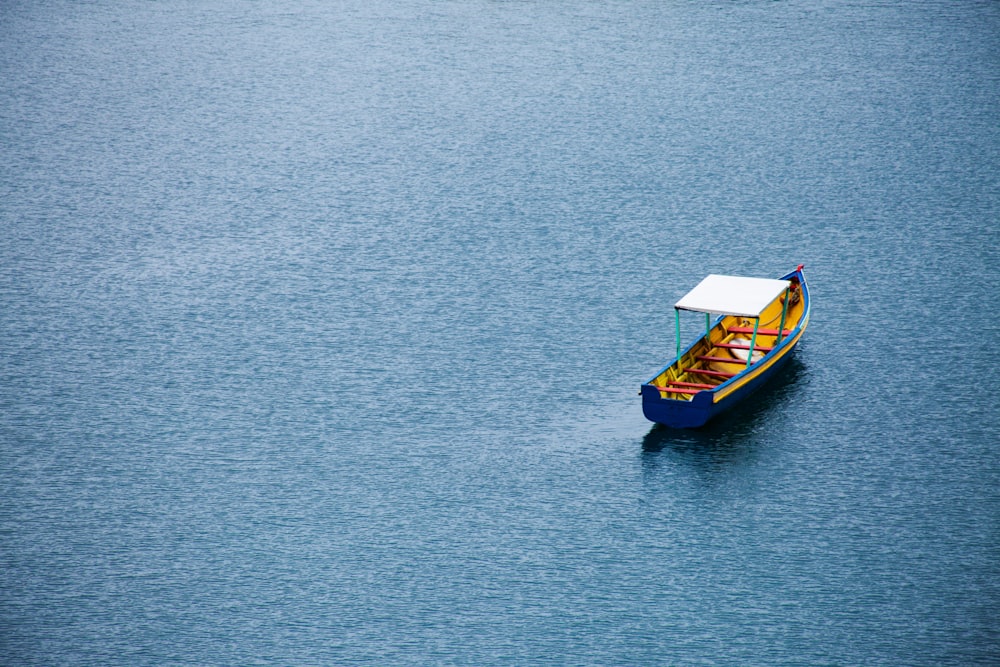 昼間の水上の茶色と青のボート