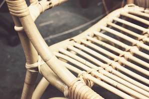 A cozy Majuli cane armchair with intricate weaving and natural finish