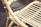 Close-up of a drum shaped woven rattan end table beside a soft fabric accent chair.