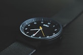 round black Braun analog watch with black band at 7:30