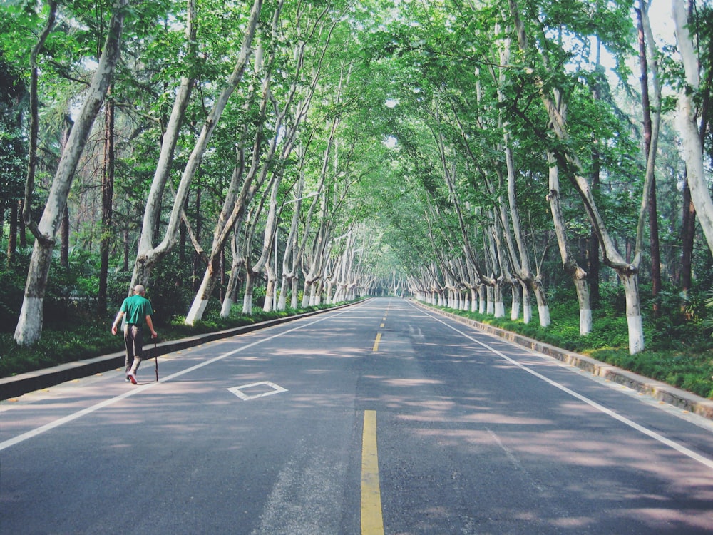 杖をついて道路を歩く人