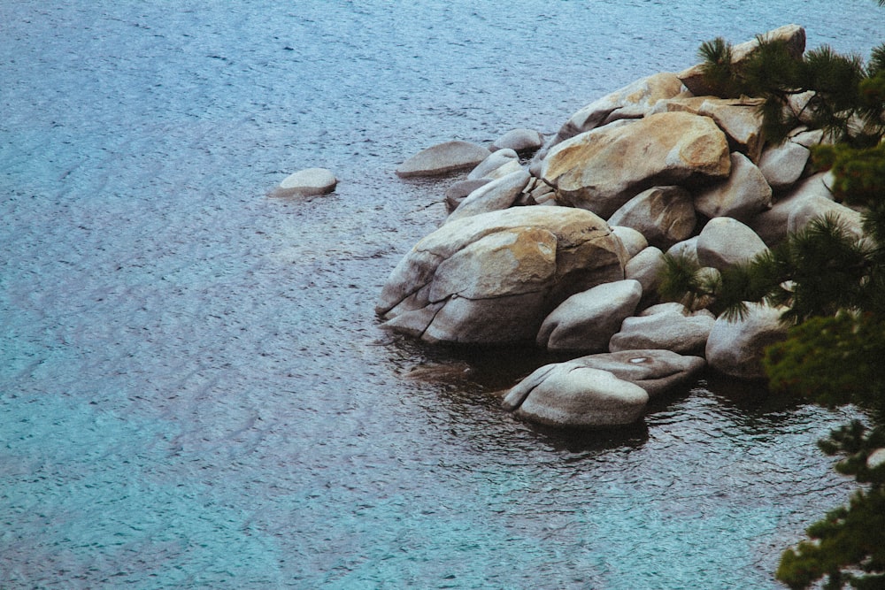 high angle photography of pile of stone beside body of water