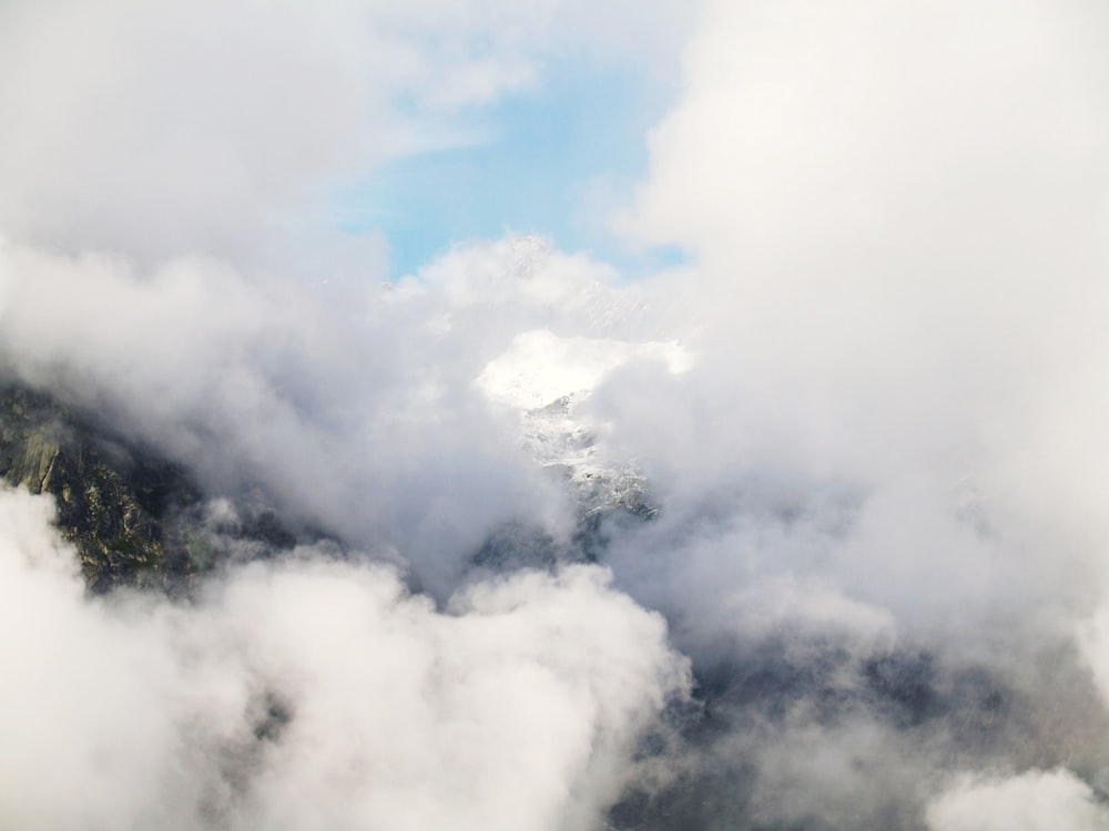 white and black mountain covered with clouds at daytime