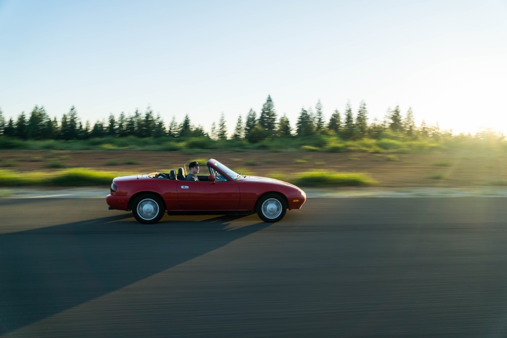 Photographie panoramique de l’homme en cabriolet rouge