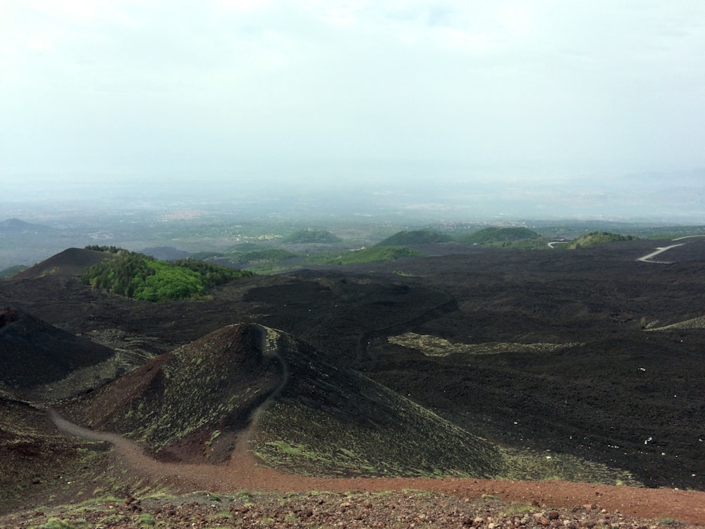 aerial photo of brown hills under cloudy sky during daytime