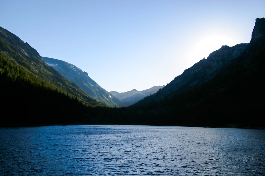 landmark photography of body of water surrounded by green mountains during daytime