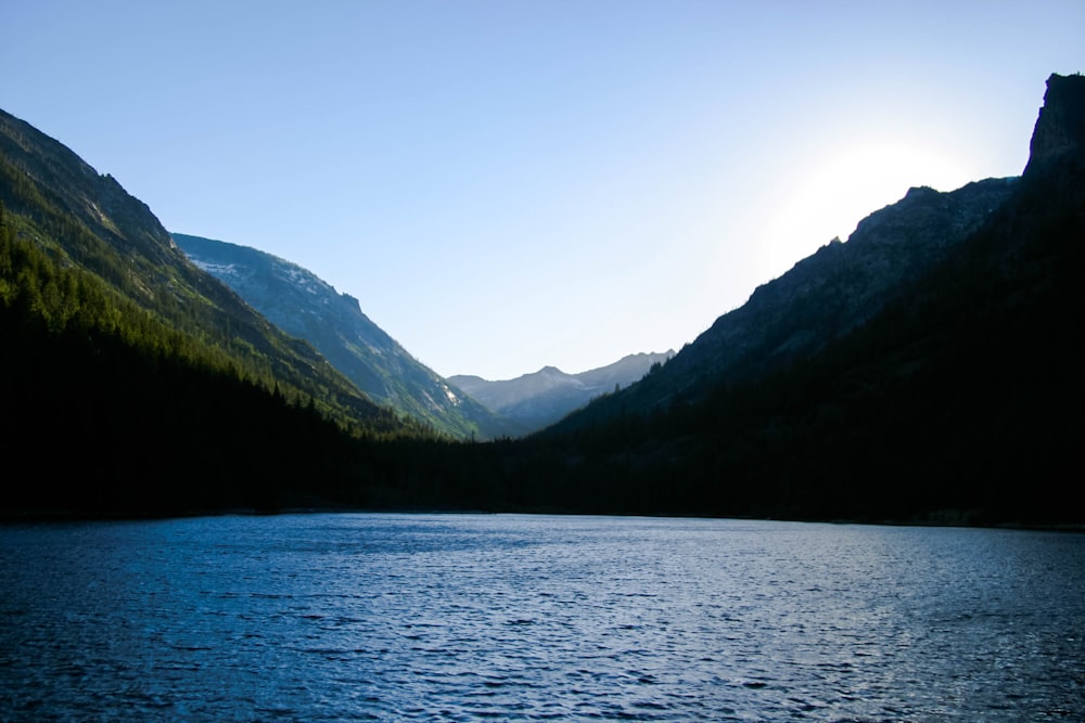 landmark photography of body of water surrounded by green mountains during daytime