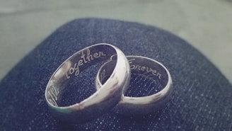 A pair of custom-made wedding rings resting on a vintage wooden surface, symbolizing lasting love.