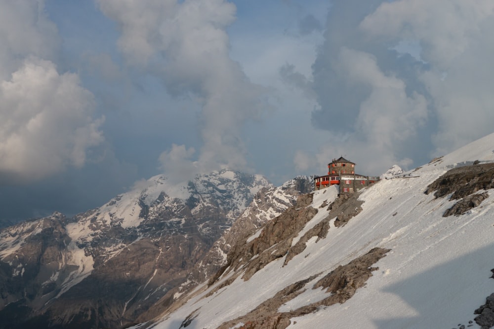 house on top of mountain under cloudy sky