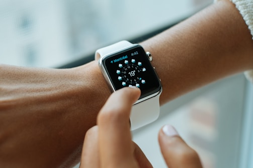 A person is interacting with a smartwatch on their wrist, displaying weather information with icons and the temperature for Montreal.