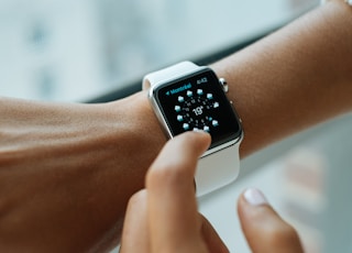 person wearing silver aluminium case Apple Watch with white Sports Band