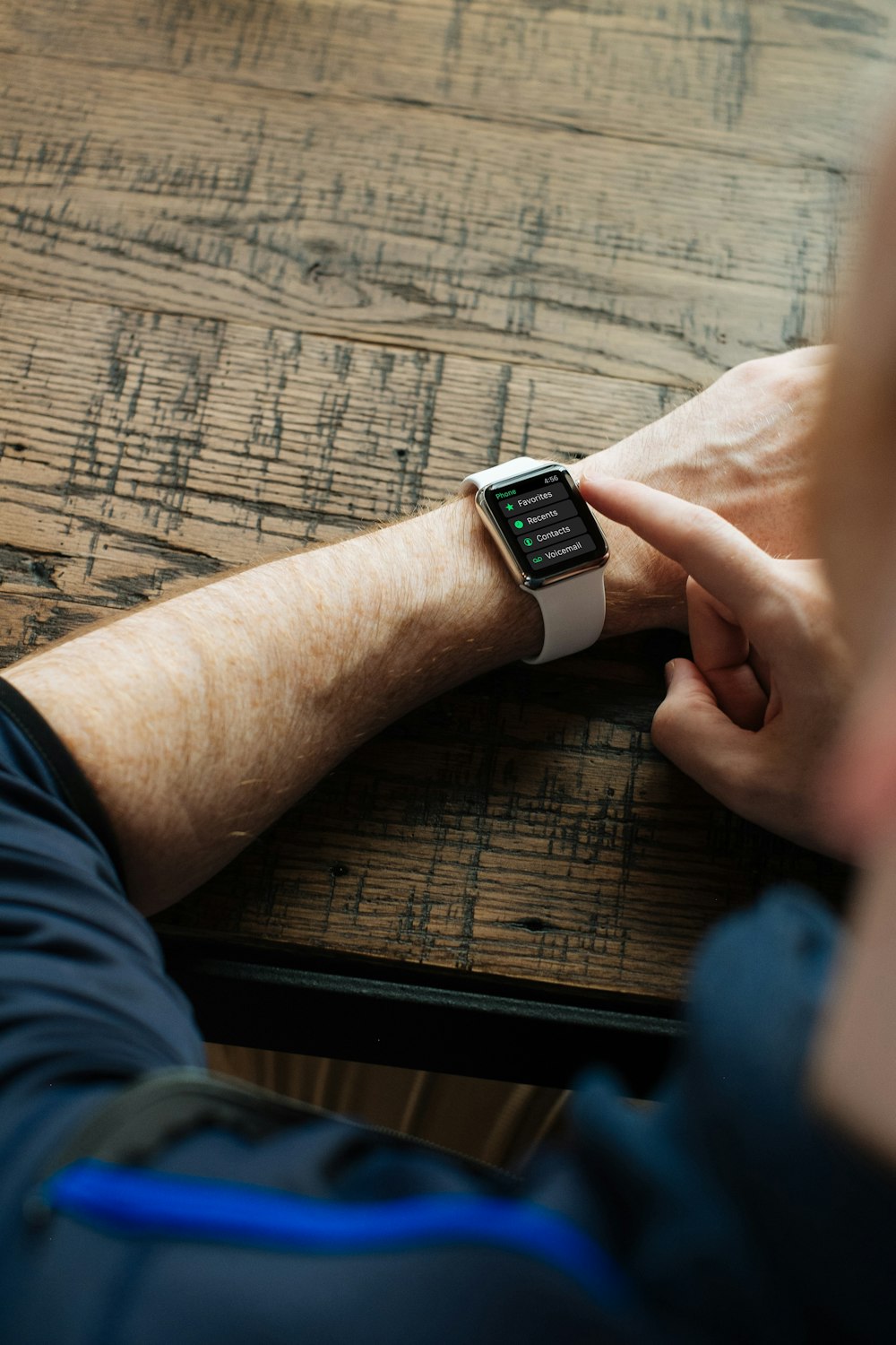 person wearing silver Apple Watch with white band