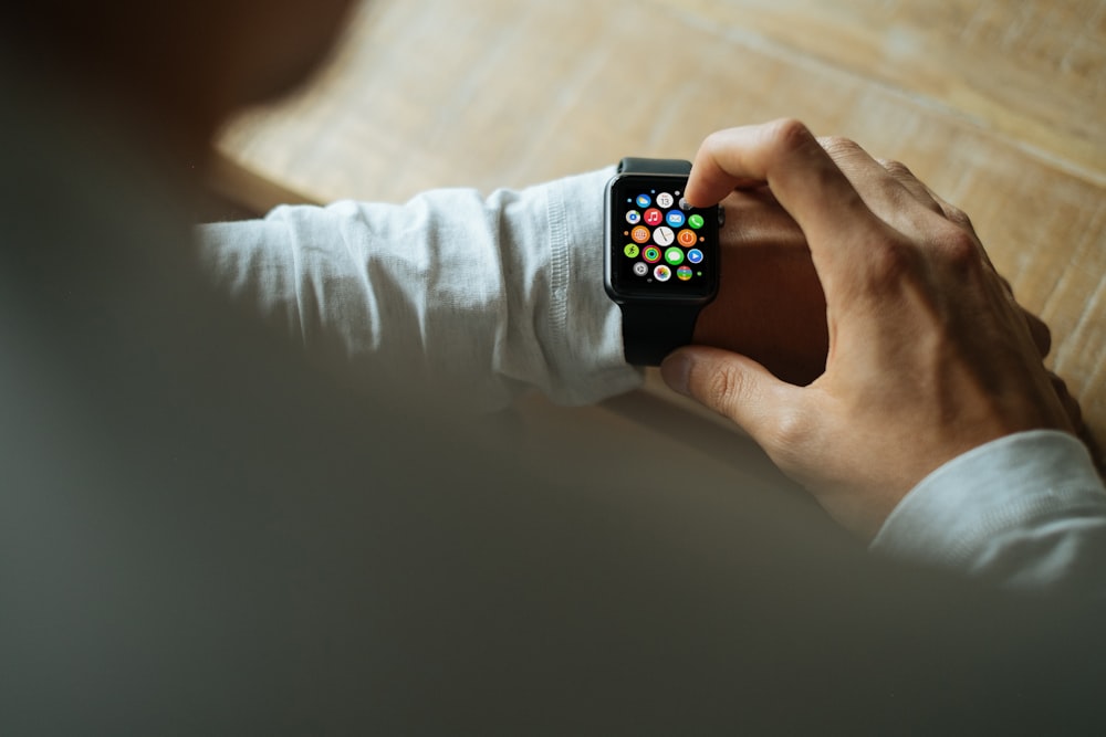 person holding Apple Watch with black Sport Band