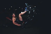 Instructor guiding a student through proper form on a leg press machine.