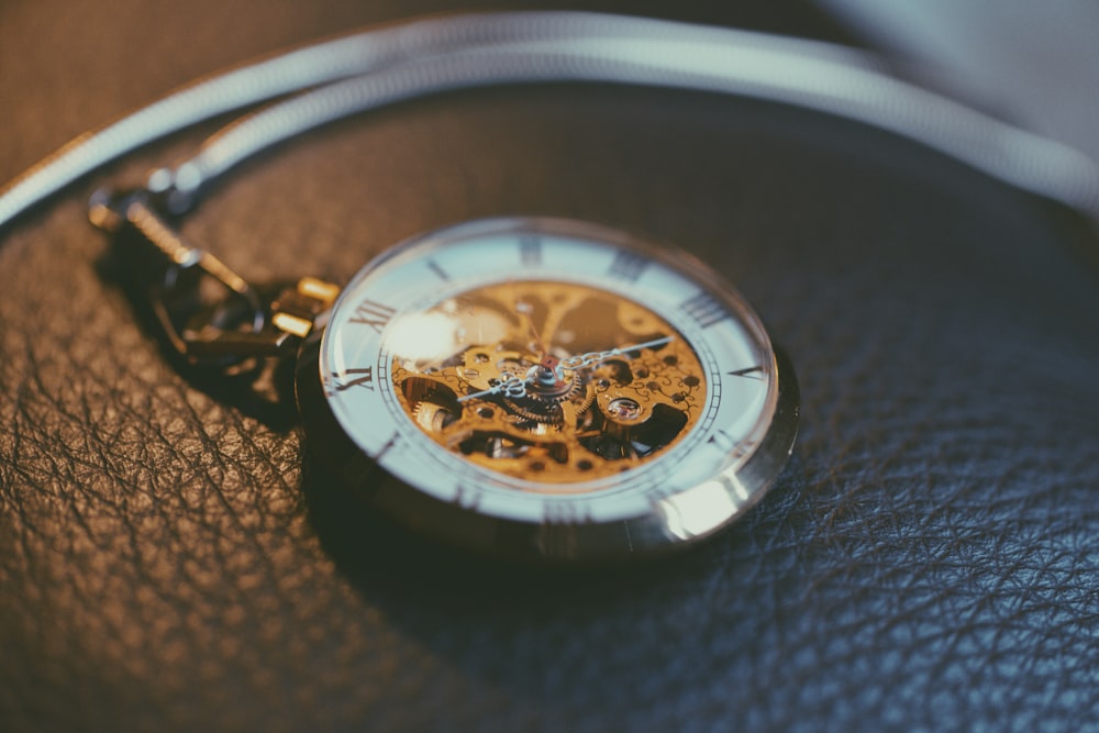 round silver-colored frame skeleton pocket watch