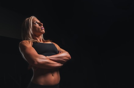 immortal body builder woman wearing black crop-top cross armed closeup photography