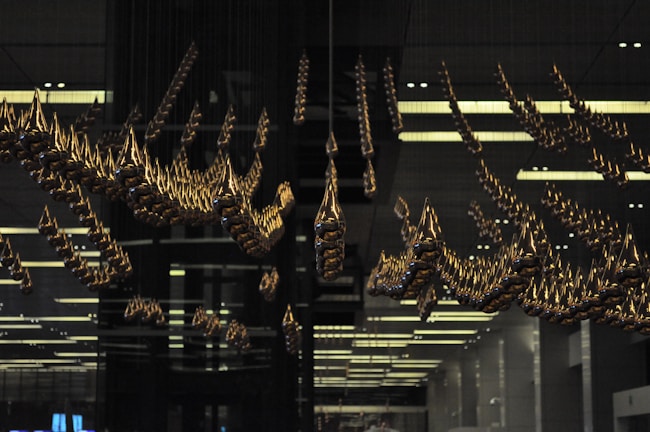 Elegant minimalist installation with suspended yellow and black elements creating shadows.