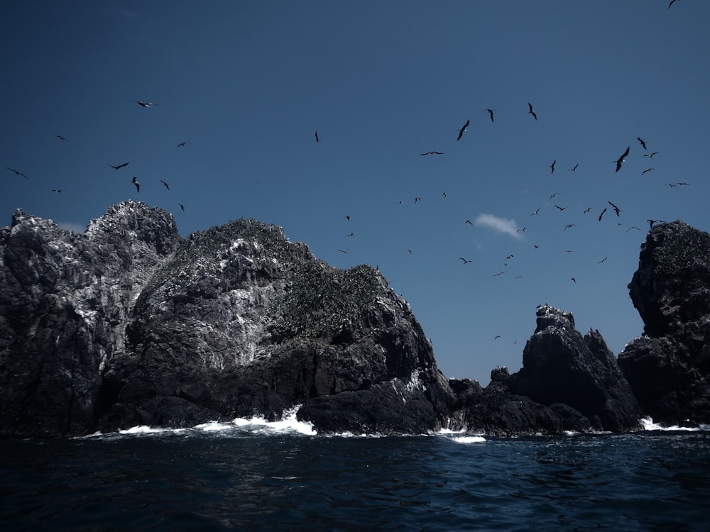 rocce grigie con onde oceaniche durante il giorno