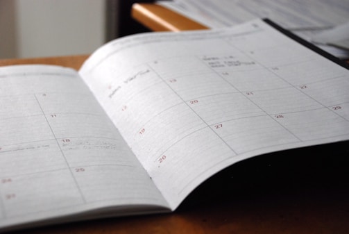 A calendar and planner open on a desk, symbolizing careful scheduling and management.