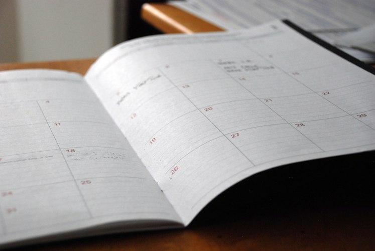 A person checking their calendar notifications on a smartphone while seated at a desk