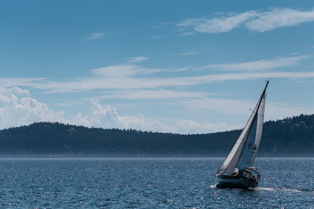 velero negro en el mar bajo el cielo azul durante el día