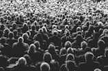 grayscale photo of people sitting on chair