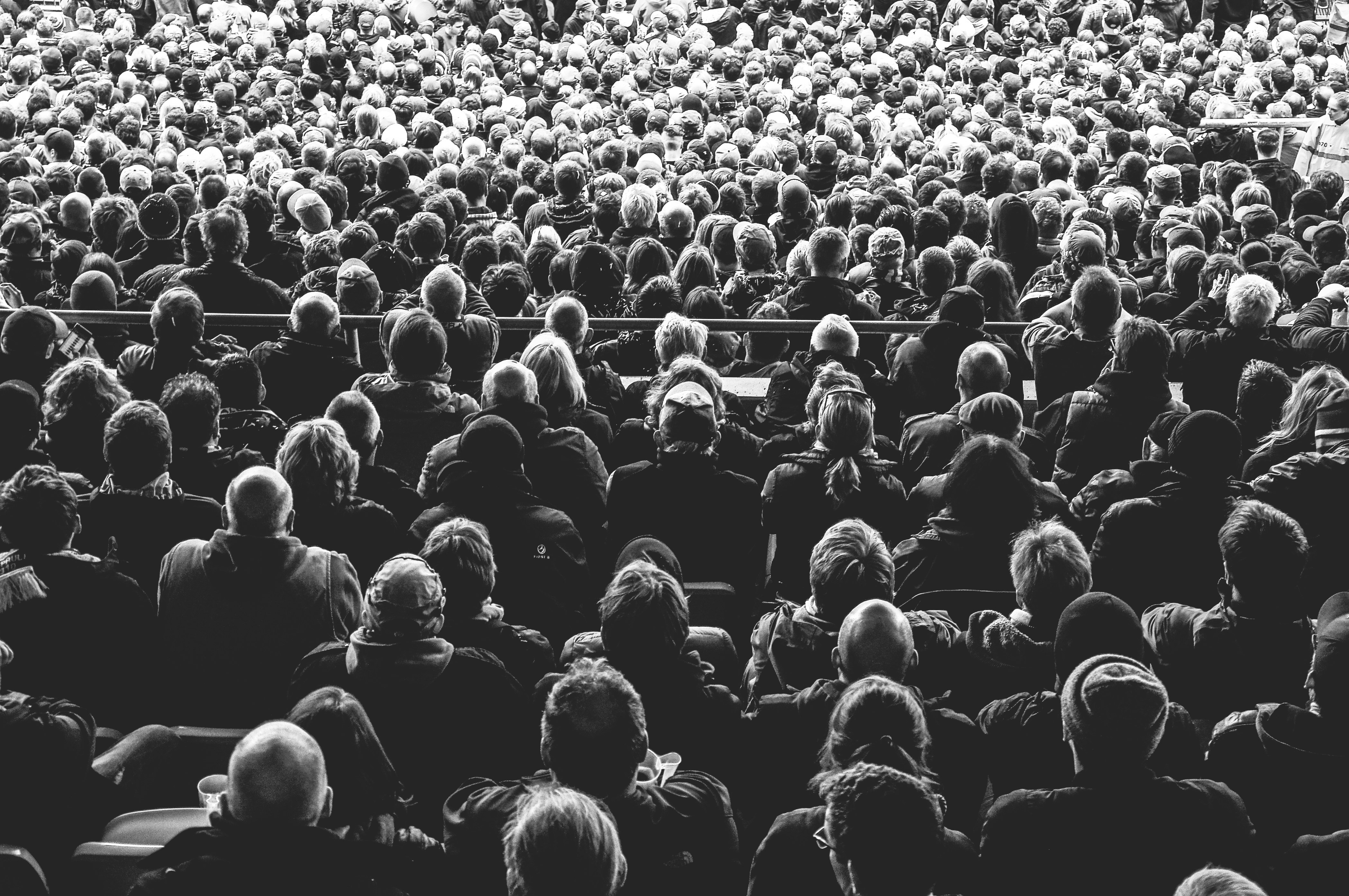 grayscale photo of people sitting on chair