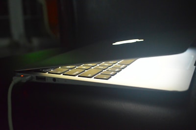 An ambsun charger connected to a laptop, glowing softly.
