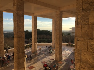 A sunlit shared patio with fountains, cozy chairs, and neighbors chatting warmly.